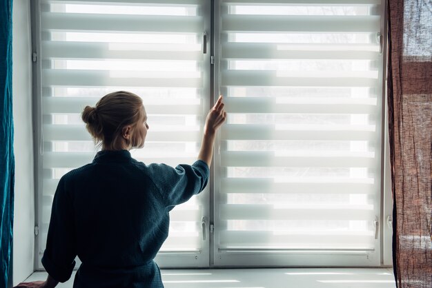 young woman gown stands near window with blinds 180532 85