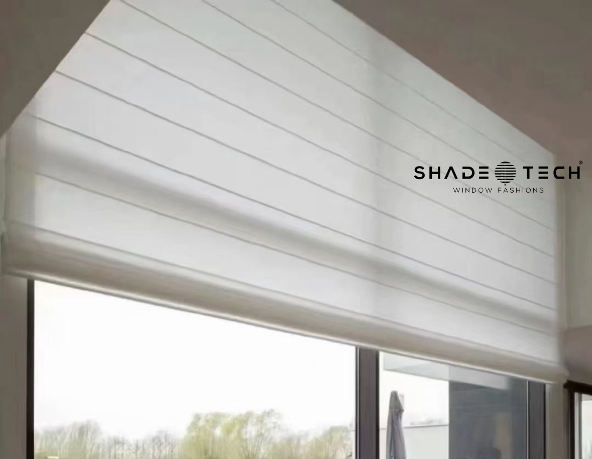 White motorized Roman shade raised above a window