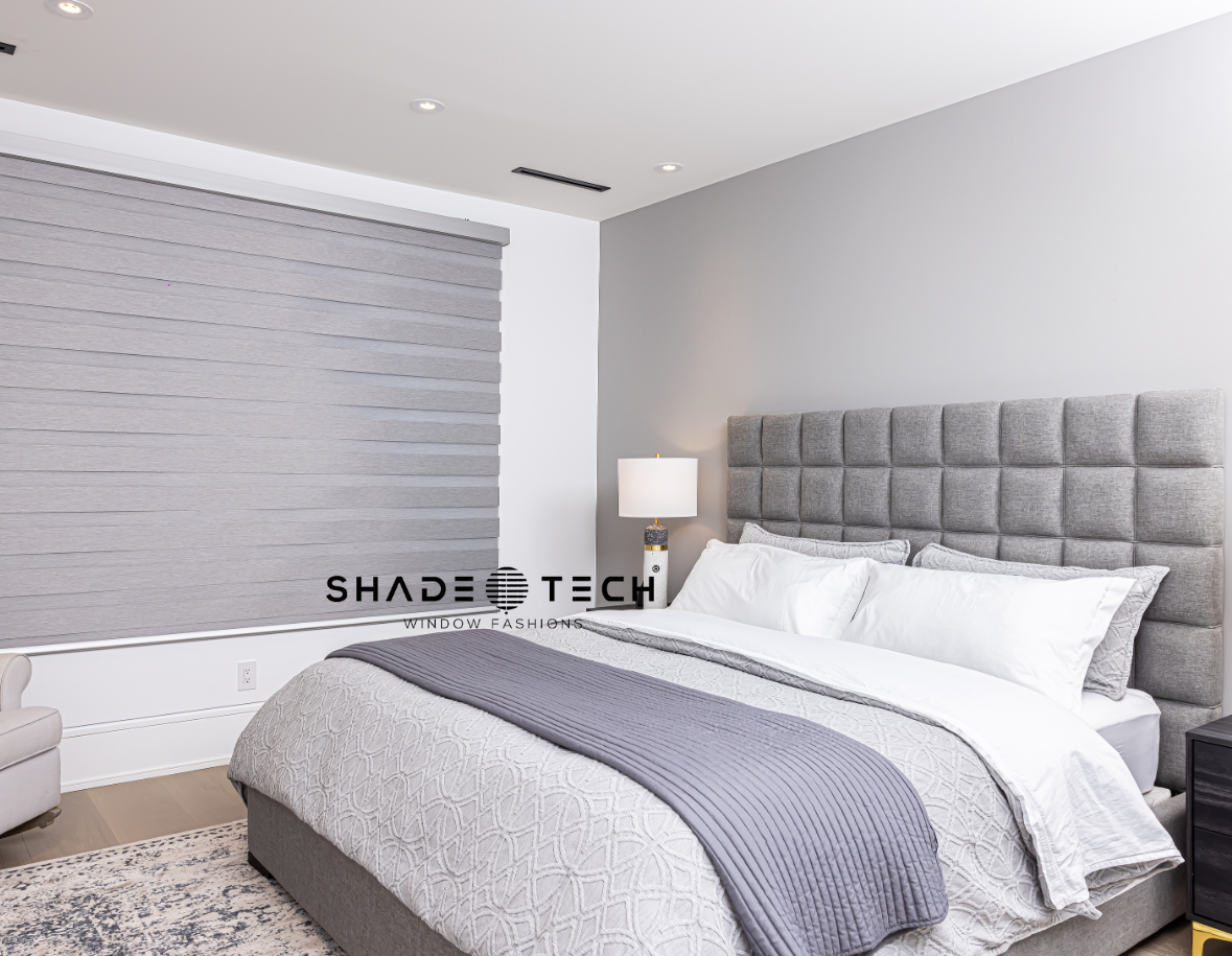 Grey duo zebra shades in a bedroom with a tufted headboard