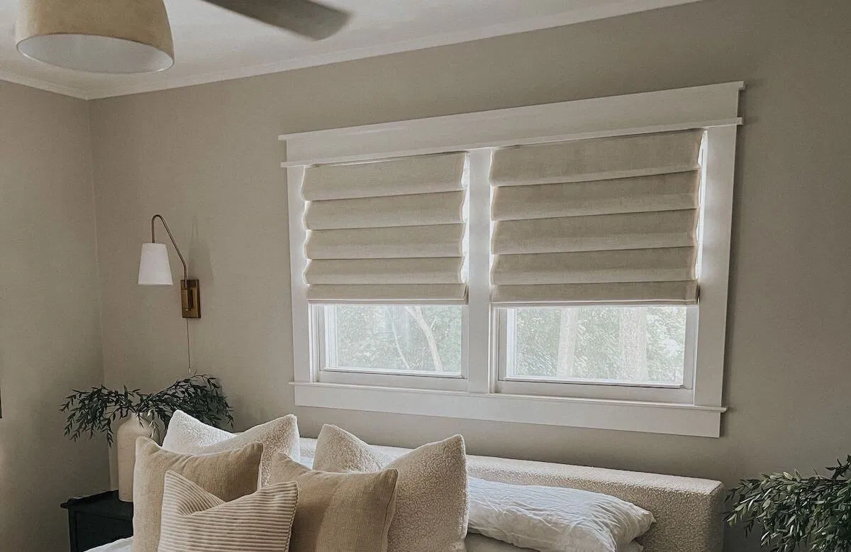 Flat Roman shades on a pair of windows in a living room