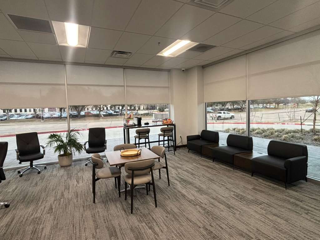 Roller shades raised to the same height across an office lounge
