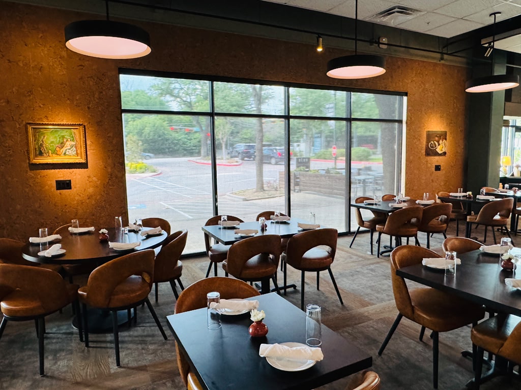 Restaurant dining room with roller shades on a large window
