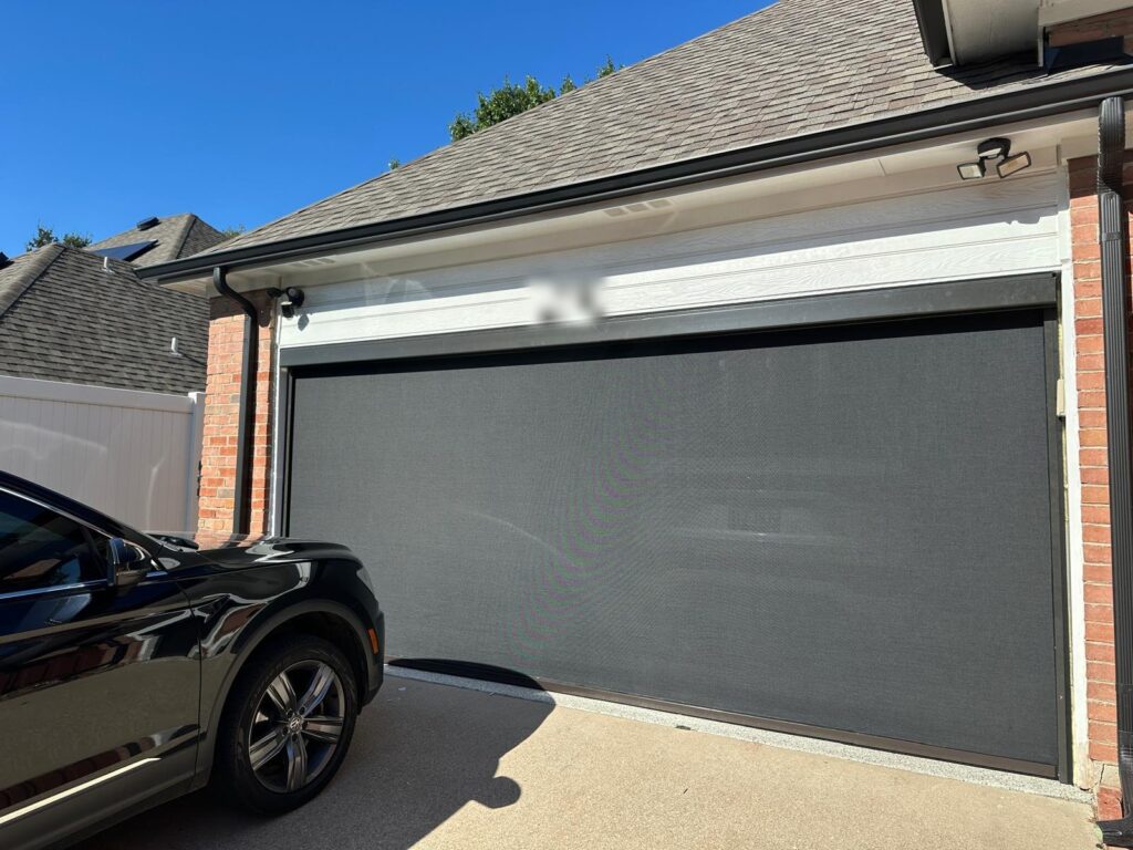 Motorized zip-track screen closing a two-car garage opening for summer airflow