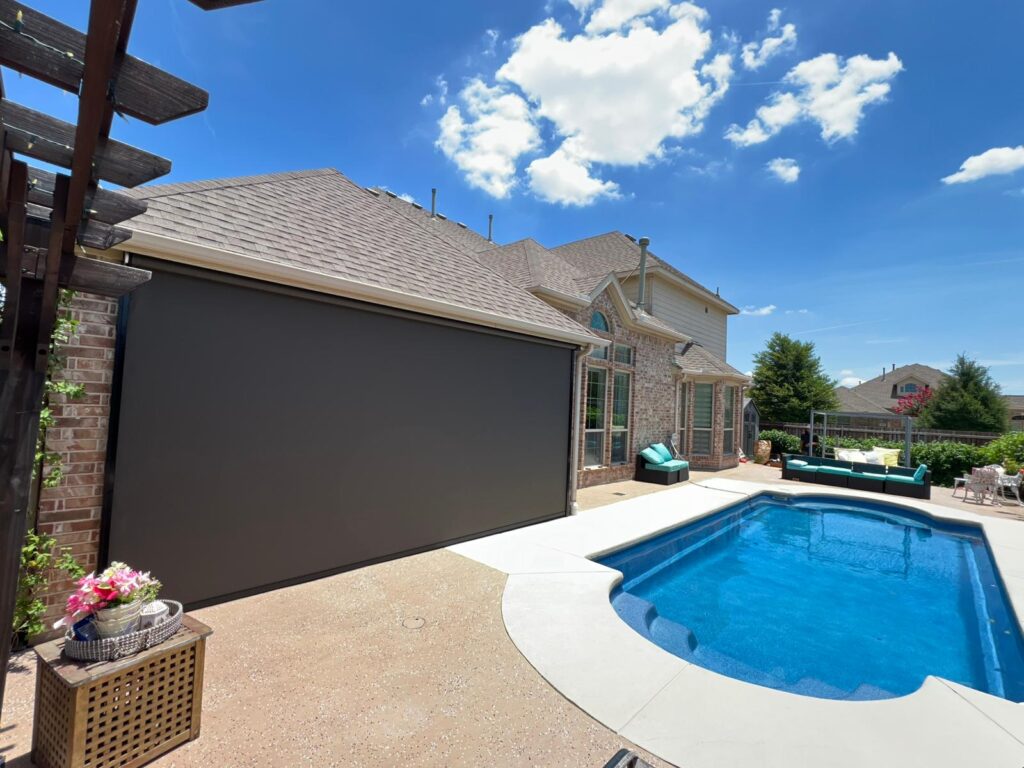 Dark zip-track screen beside a backyard pool