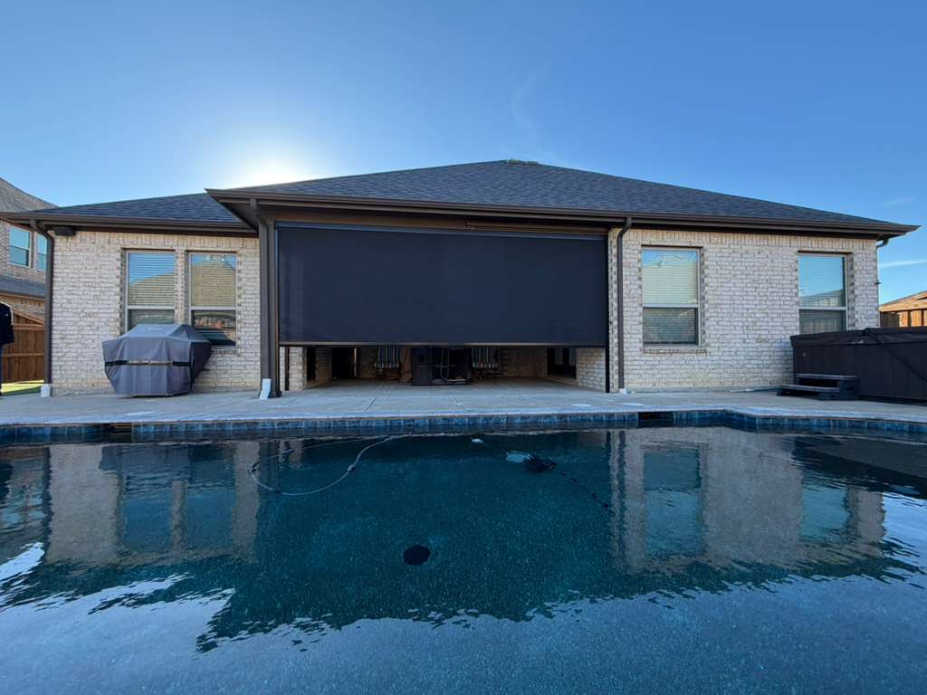 Black zip-track screen on a covered patio across a pool